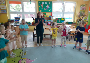 Krasnoludki razem z gościem klaszczą i śpiewają w zabawie przy muzyce.