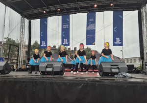 Dziewczynki z koła tanecznego prezentują figurę taneczną na scenie