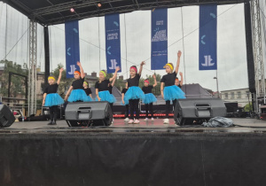 Dziewczynki z koła tanecznego prezentują figurę taneczną na scenie