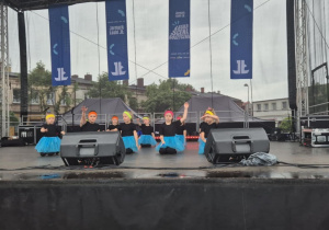 Dziewczynki z koła tanecznego prezentują figurę taneczną na scenie