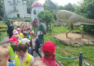 Dzieci oglądają figury dinozaura.