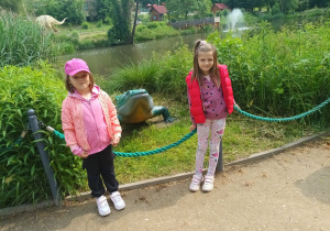 Lila i Julka stoją przy figurce krokodyla.