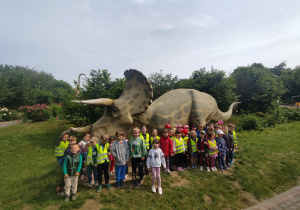 Wspólne zdjęcie dzieci z figurką dinozaura.