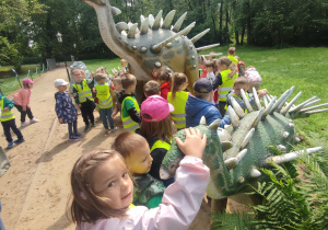 Latika głaszczę głowę dinozaura.