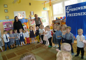Dzieci śpiewają piosenkę, ilustrując ją ruchem.