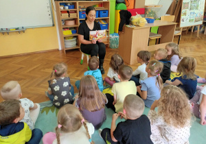 Dzieci z zainteresowaniem oglądają kolorowe ilustracje.