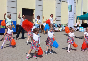 Dziewczynki z grupy „Krasnoludków” tańczą na scenie wspólnie z rodzicami.