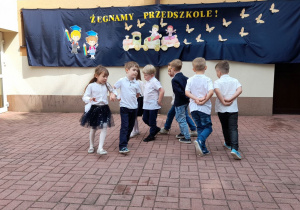 Starszaki tańczą parami w kole.