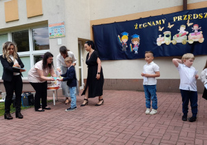 Nikodem odbiera książkę od pani Pauliny.
