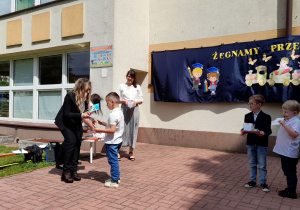 Antoś odbiera dyplom od Pani Dyrektor.