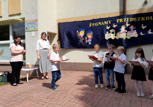 Zadowolony Kubuś z dyplomami i upominkami.