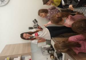 Pani Agnieszka pokazuje różne rodzaje szczotek do modelowania włosów.