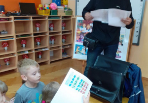 Dzieci z zainteresowaniem oglądają znaczki pocztowe