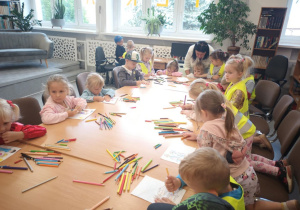 Dzieci rysują przy stole bohaterów bajki „Brat i siostra”.