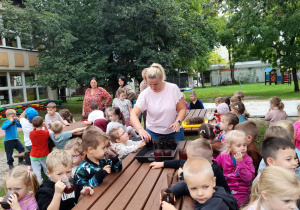 Po intensywnych zabawach dzieci piją sok.