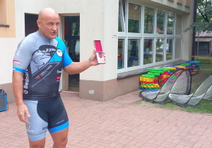 Mistrz Polski pokazuje dzieciom odznaczenie przyznane przez Prezydenta RP, Brązowy Krzyż Zasługi dla za działalność w dziedzinie sportu.