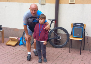 Pan Grzegorz pozuje do zdjęcia z Jankiem, który otrzymał od sportowca jeden z jego medali.