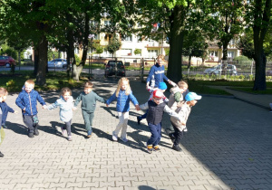 Krasnoludki trzymają się z ręce i biegają.