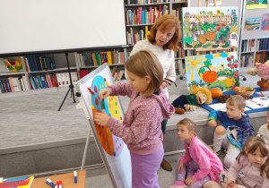 Lilia przelicza grzyby na jednej z części koła i przypina cyfrę.