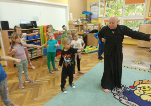 Przedszkolaki według instrukcji trenera wyprowadzają cios.