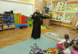 Trener pokazuje dzieciom replikę miecza samurajskiego - Katana.