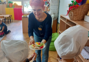 Przedszkolaki częstują kanapkami panią Agnieszkę.