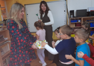 Dzieci z grupy Żabek chętnie przyjmują słodki poczęstunek.