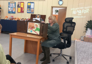 Bibliotekarka prezentuje dzieciom Teatrzyk kamishibai.