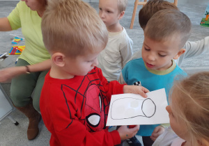 Franek podświetla latarką kartkę ze słoikiem.