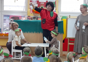 Maja i Wiktoria z grupy Biedronek odgadują barwę owoców i sprawdzają, na jaki kolor zabarwi się woda w buteleczce.