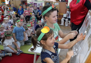 Klemens i Maja z grupy Misiaczków segregują do słoików warzywa wg kolorów.