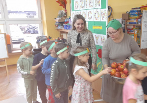 Emilka z grupy Misiaczków częstuje się jabłkiem.