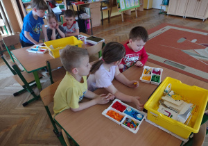 Dzieci układaja klocki Lego.