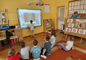 Leoś gra w warcaby na tablic ineteraktywnej.