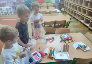 Leoś, Antoś i Kasjan robią zakupy w sklepie zabawkowym.